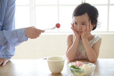 子供に野菜野菜を食べさせる画像